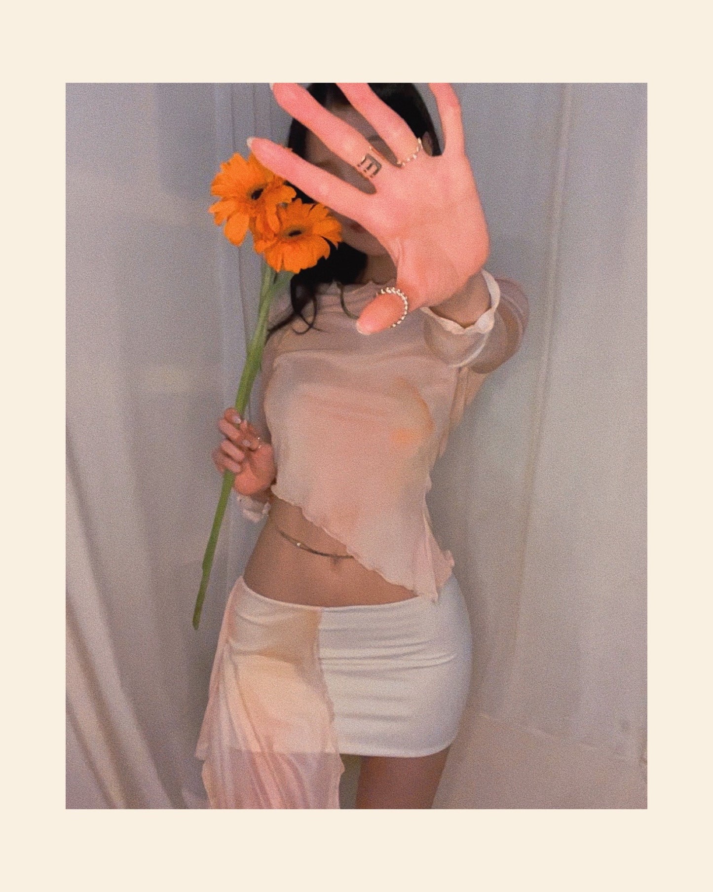 An asymmetrical sunset orange printed mini skirt in nylon fabric and mesh panel. Styled with an asymmetrical sunset orange printed long sleeve mesh top.
