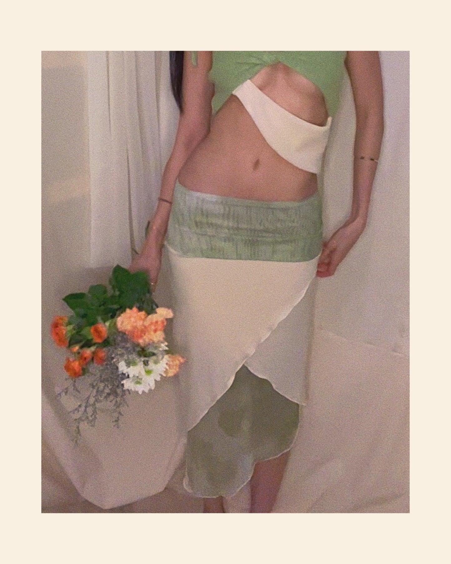 An asymmetrical matcha green modal midi skirt with printed sheer bottom panel and printed sheer wide waistband.