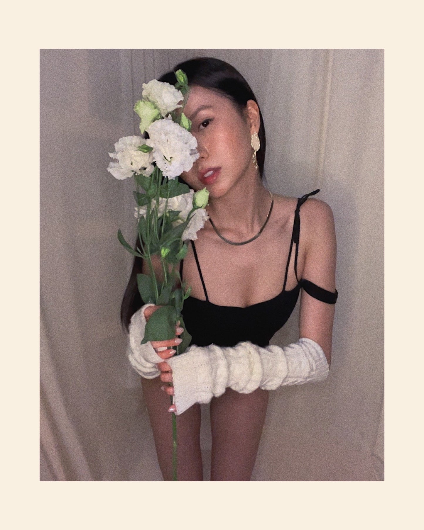 A black shapewear nylon bodysuit, with side mesh panels, classic neckline and double stylish shoulder straps. Styled with white knit arm warmers.